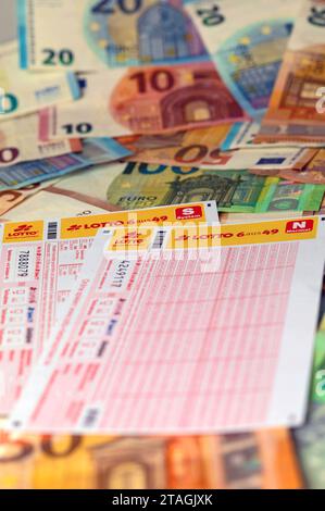 Lottoschein auf Geldscheinen. In Deutschland betreibt der Deutsche lotto- und Totoblock als Zusammenschluss der Landes-Lotteriegesellschaften das Lottospiel. Lotto ist ein Glücksspiel, bei dem der Spieler gegen einen finanziellen Einsatz auf das Ziehen vorher getippter Zahlen aus einer begrenzten Zahlenmenge setzt. Symbolfoto, Themenfoto *** biglietto della lotteria sulle banconote in Germania, il lotto tedesco e Totoblock, un'associazione di compagnie di lotteria statali, gestisce il gioco della lotteria lotto è un gioco d'azzardo in cui il giocatore scommette sull'estrazione di numeri precedentemente selezionati da una serie limitata Foto Stock