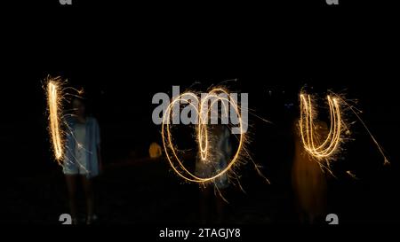 Una parola che AMO è stata scritta con i fuochi d'artificio di sparkler su sfondo nero Foto Stock