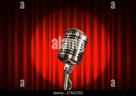 Microfono in metallo vintage su sfondo rosso con riflettore, concetto. Spettacolo, palco e stand up show Foto Stock