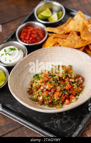 Pico de gallo di cucina messicana con salse da immergere su un tavolo di legno Foto Stock