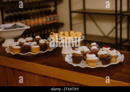 Una varietà di cupcake appena sfornati esposti su un ripiano Foto Stock