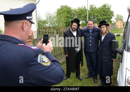 Belz, Ucraina - 11 maggio 2015: Un poliziotto fa foto di ebrei ultra-ortodossi nella città di Belz, nella regione di Leopoli. Foto Stock