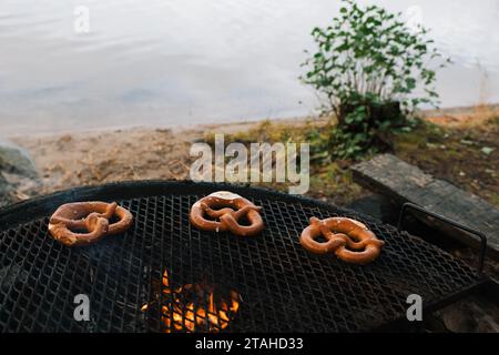 pretzel che cucinano su un fuoco aperto vicino al mare Foto Stock