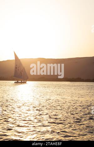 Tradizionale Felucca che naviga sul Nilo durante l'ora d'oro ad Assuan Foto Stock