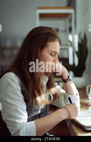 Giovane caucasico con lunghi capelli biondi in un bar. Foto Stock