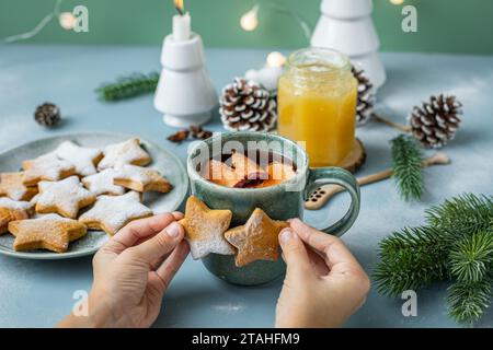 tavolo da pranzo di natale con biscotti al pan di zenzero in mano al bambino Foto Stock