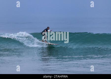 Un surfista più anziano prende un'onda su Cape Cod Foto Stock