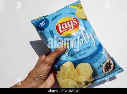 Deposita i chip in un pacchetto blu chiaro. Cialde di patate di Lay con sapore di sale e pepe dall'India Foto Stock