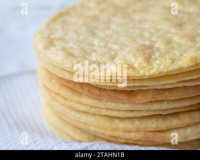 Primo piano di un mucchio di sottili strati di burro rotondi al forno su un asciugamano bianco pronto a preparare una pasta sfoglia di pasta sfoglia alla Napoleone. Foto Stock