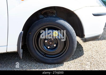 Ruota di scorta salvaspazio sulla ruota anteriore di una Ford Focus bianca, Regno Unito Foto Stock