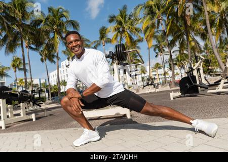 Un atleta afro-americano che si allunga nella palestra all'aperto di Miami Foto Stock