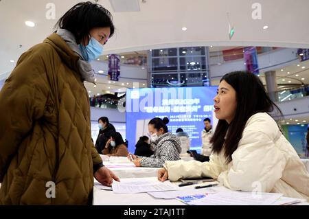 BINZHOU, CINA - 1° DICEMBRE 2023 - chi cerca lavoro cerca informazioni sull'occupazione in una fiera del lavoro per i laureati a Binzhou, nello Shandong della Cina orientale Foto Stock