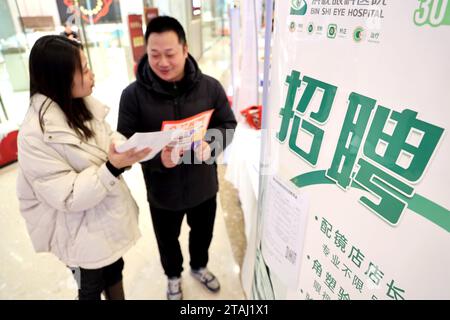 BINZHOU, CINA - 1° DICEMBRE 2023 - chi cerca lavoro cerca informazioni sull'occupazione in una fiera del lavoro per i laureati a Binzhou, nello Shandong della Cina orientale Foto Stock