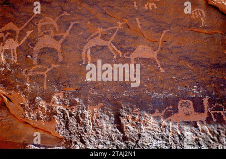 Primo piano vista frontale delle iscrizioni preistoriche in pietra e dei petroglifici fatti dai beduini nomadi sulla superficie delle rocce di arenaria rossa di Wadi Rum Foto Stock
