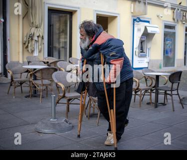 Belgrado, Serbia, 19 novembre 2023: Un uomo che cammina per strada usando stampelle Foto Stock