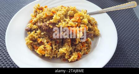 Primo piano del plov, piatto della cucina tradizionale uzbese a base di carote e carne Foto Stock