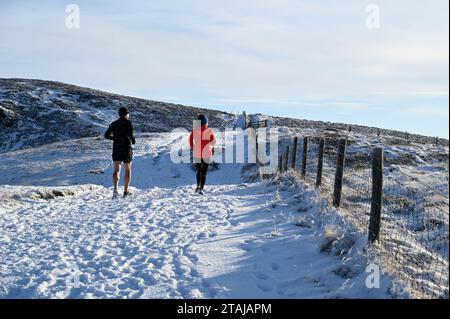 Edimburgo, Scozia, Regno Unito. 1 dicembre 2023. La neve arriva nel Pentland Regional Park. Jogging sulla neve. Crediti: Craig Brown/Alamy Live News Foto Stock