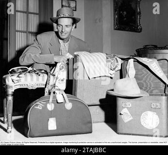 Negli anni '1950 Un uomo con diversi tipi di bagagli davanti a sé, valigia, borse e oggetti e dettagli di moda come un cappello e delle collane. Una bandiera con Beverly Hills e' vista a destra, indicando che ha viaggiato da li'. È l'attore Gustav Wally 1905-1966. Svezia 1952. Kristoffersson Foto Stock