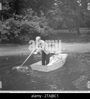 Negli anni '1940 Un uomo in piedi su una piccola barca a vela, che utilizza un reo per muoversi in avanti, poiché l'albero e la vela non sono montati e sdraiati nella barca. 1945. Kristoffersson rif. P40-1 Foto Stock