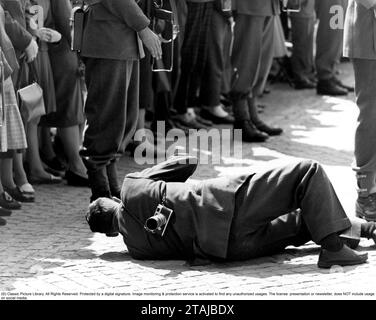 Premi fotografi. I media sono molto interessati a coprire la visita di stato della regina Giuliana dei Paesi Bassi in Svezia nel 1957. Un fotografo maschio è visto sdraiato per terra per avere una visione ancora migliore dell'evento. Foto Stock
