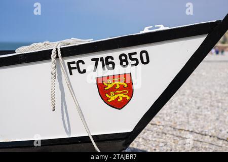 Yport, Francia - 21 luglio 2022: La parte anteriore di un piccolo peschereccio bianco sulla spiaggia di Yport, giorno di sole in estate, stemma rosso Foto Stock