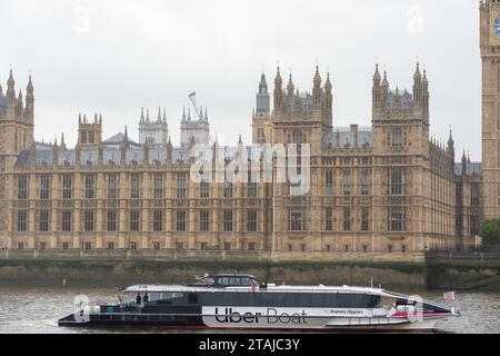 Londra, Regno Unito. 21 novembre 2023. Una Uber Boat passa per il Palazzo di Westminster sul Tamigi, sede della politica in Inghilterra, della camera dei comuni e della camera dei lord a Londra. I laburisti sono attualmente sostanzialmente in vantaggio nei sondaggi sopra i conservatori e si prevede che vinceranno le elezioni generali il prossimo anno. Credito: Maureen McLean/Alamy Foto Stock
