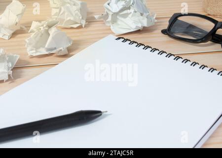 Blocco note con sfondo di carta spazzatura su scrivania in legno. Copia spazio. Foto Stock