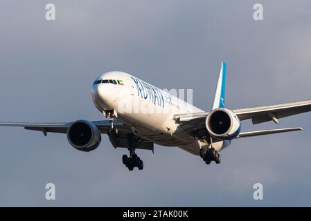 Kuwait Airways Boeing 777-300/ER aereo di linea jet 9K-AOD in finale per atterrare all'aeroporto di Londra Heathrow, Regno Unito, in tarda inverno, al sole contro il cielo oscurante Foto Stock