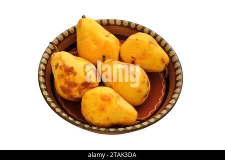 Pere in un piatto di argilla beige. Pere da fattoria in un recipiente rustico. Isolare su sfondo bianco. Raccolto. Foto Stock