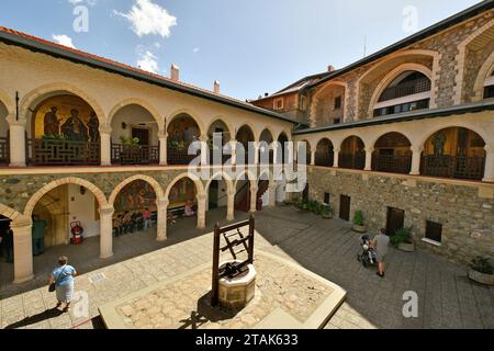 Pedoulos, Cipro - 28 settembre 2023: Gruppo di turisti nel cortile interno del monastero Kykkos con navata con icone Foto Stock