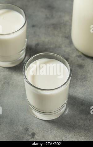 Latte vaccino intero in un bicchiere per erba biologica Foto Stock