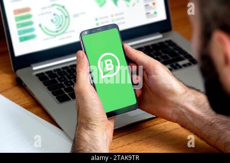 Logo dell'app WhatsApp Business sullo schermo del telefono cellulare nelle mani di un uomo. Smartphone con schermo di sfondo verde e logo bianco. ROSARIO, A Foto Stock