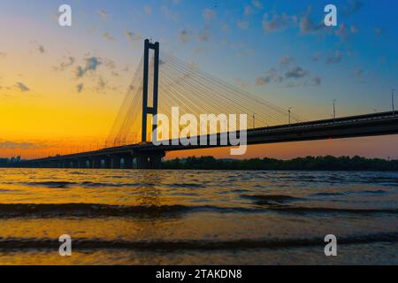 Ponte in auto visto dall'acqua al tramonto. Foto Stock