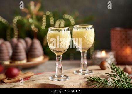 Due bicchieri di eggnog con nidi di vespa o alveari - biscotti di Natale tradizionali sullo sfondo Foto Stock