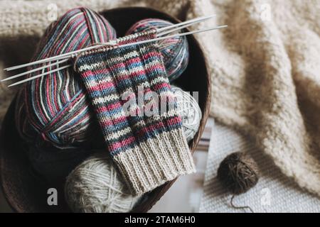 Maglia a mano con aghi e palla di filato. Concetto per una vita lenta fatta a mano e hygge. Foto Stock