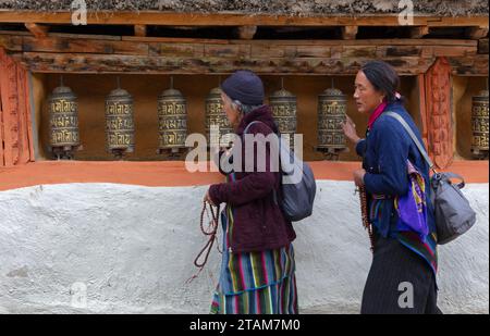 I pellegrini girano le ruote di preghiera al Monastero di lo Gekar nel villaggio di Ghar, il più antico gompa buddista del Nepal, costruito da Guru Rimpoche nell'VIII secolo - Mus Foto Stock