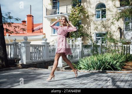 donna in leggero abito estivo in una passeggiata per le strade della città Foto Stock