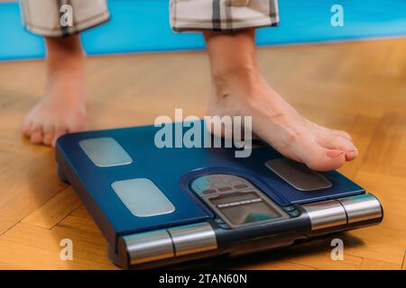 Donna che usa scale di composizione corporea Foto Stock