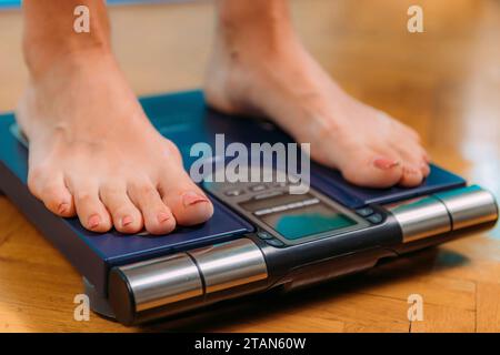 Donna che misura la composizione corporea con scale digitali Foto Stock