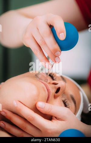 Terapia di coppettazione del viso Foto Stock