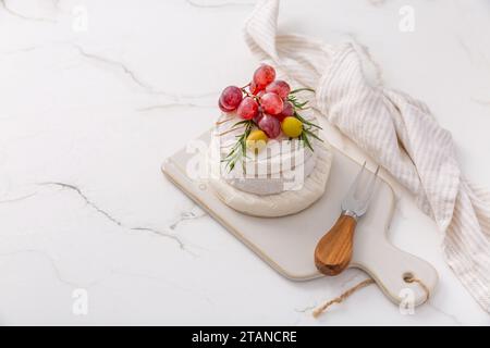 Piatto di formaggi con Camembert francese e formaggio Skyr con uva, olive e vino di rosa Foto Stock