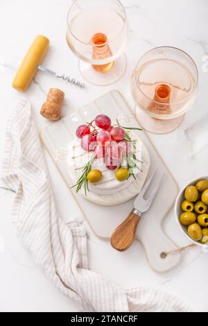Piatto di formaggi con Camembert francese e formaggio Skyr con uva, olive e vino di rosa Foto Stock