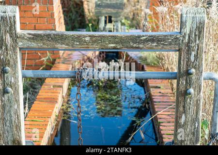 Pompa di drenaggio vecchia, in disuso e abbandonata sulla riva del fiume Foto Stock