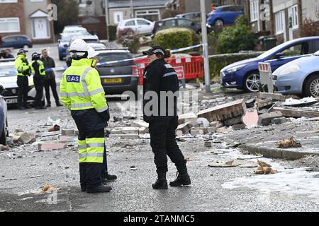 Ingegneri del gas e agenti di polizia sulla scena di Baberton Mains Avenue, Edimburgo, dopo che un uomo di 84 anni è morto a seguito di un'esplosione in una casa il venerdì sera. Data immagine: Sabato 2 dicembre 2023. Foto Stock