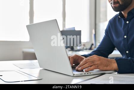 Uomo d'affari che digita su un notebook e che lavora con soluzioni di intelligenza artificiale su un computer. Primo piano Foto Stock