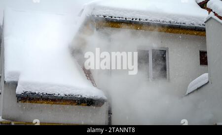 Vapore o fumo che fluisce dal sistema di riscaldamento a gas in casa privata nelle fredde giornate invernali durante le nevicate. Concetto di energia, ecologia, riscaldamento e inquinamento. Foto Stock