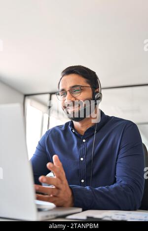 Un operatore indiano di call center che lavora con la cuffia e l'auricolare in un ufficio di assistenza clienti. Foto Stock