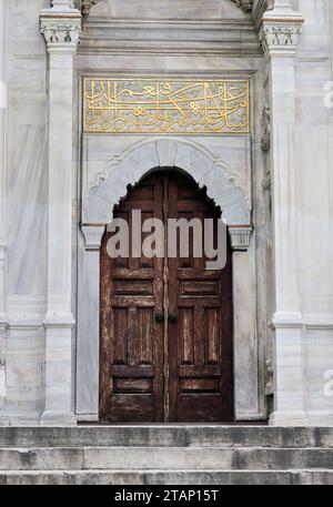 Una porta rustica in legno si apre, fiancheggiata da una scala in pietra a Istanbul, Turchia. Foto Stock