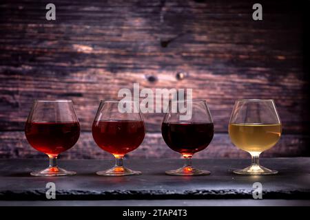 Diverse varietà di vino in bicchieri sullo sfondo delle tavole Foto Stock