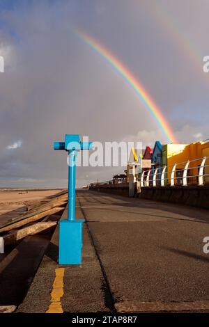 Arcobaleno sulla spiaggia e sul lungomare di Prestatyn, nel Galles del Nord Foto Stock